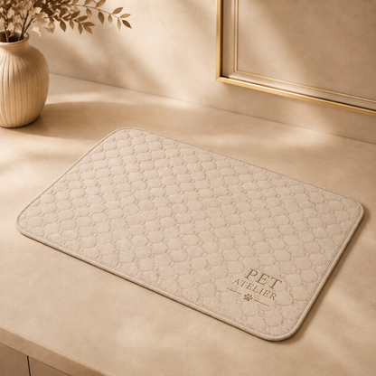 Tappetino imbottito PET ATELIER beige con motivo trapuntato, presentato in ambientazione luxury con dettagli marmo e decorazioni eleganti